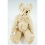 A late 19th / early 20th Century diminutive golden plush Teddy bear, having a humped back,