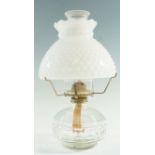 A vintage pressed glass and brass oil lamp, having a single four-prong burner and a white glass