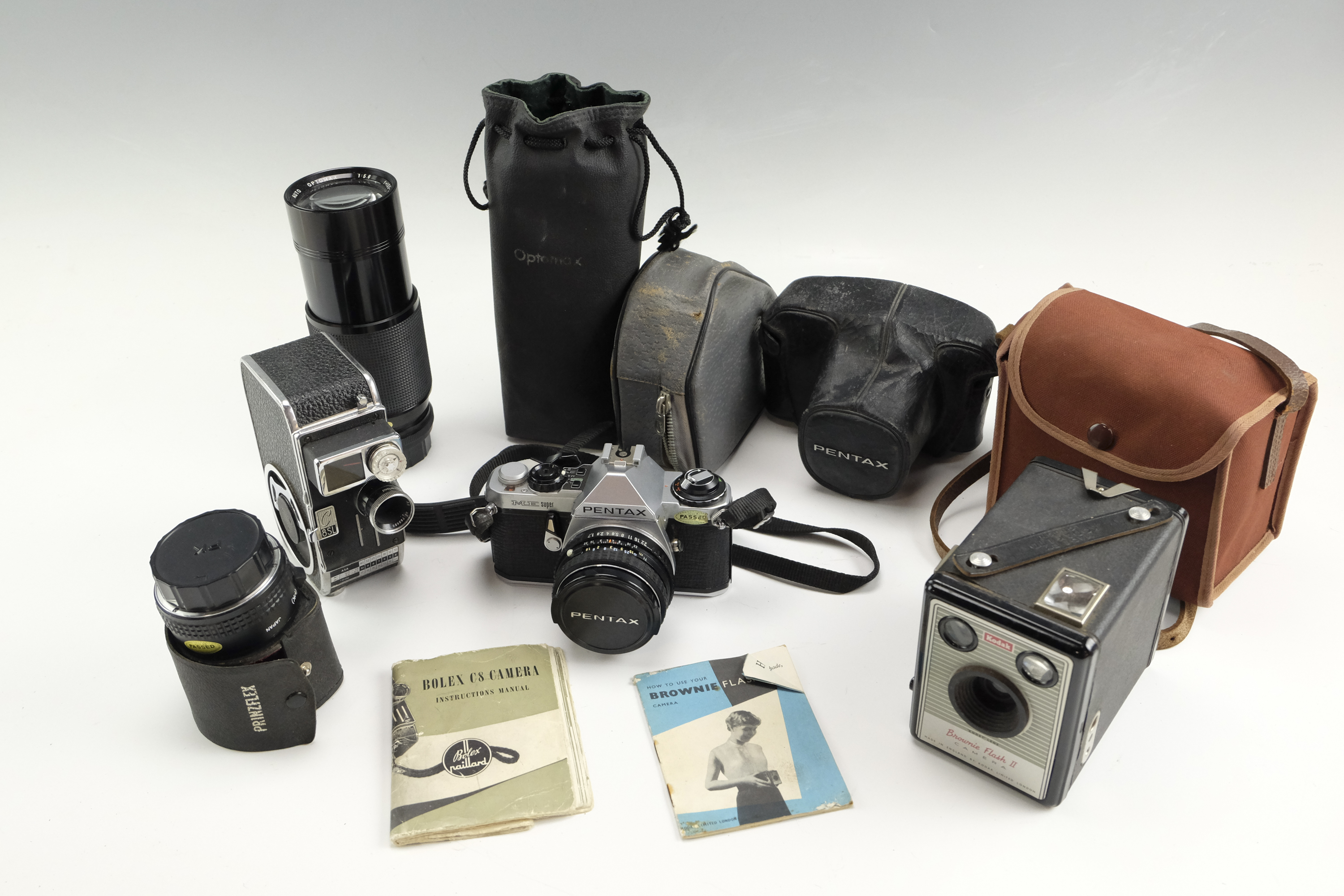 A Pentax ME Super film camera together with a Kodak Brownie Flash II, a Bolex C8SL cine camera, an