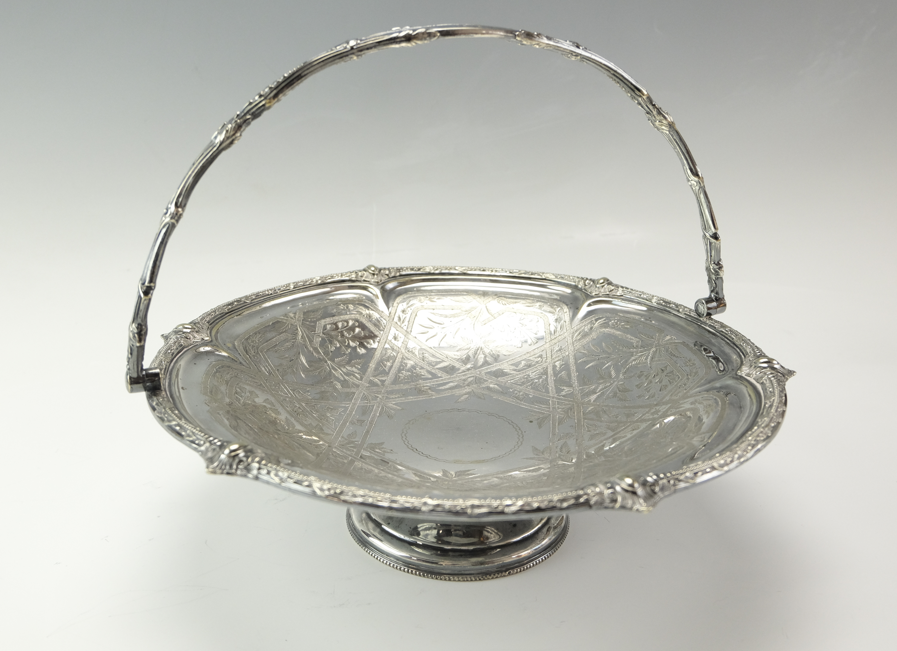 A late 19th Century electroplate swing handled cake basket having engraved decoration, 30 cm