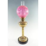 A Victorian columnar brass and etched cranberry glass oil lamp, having a 'Lewtas' duplex cornet