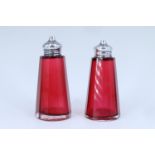 A pair of Edwardian silver mounted cranberry glass salt and pepper pots, of faceted conical form,