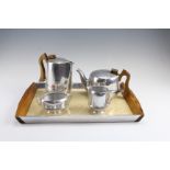 A 1950s Picquot ware magnalium and teak four piece teaset on conforming tray