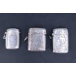 Three early 20th Century silver fob vesta cases; respectively foliate engraved and centred by a