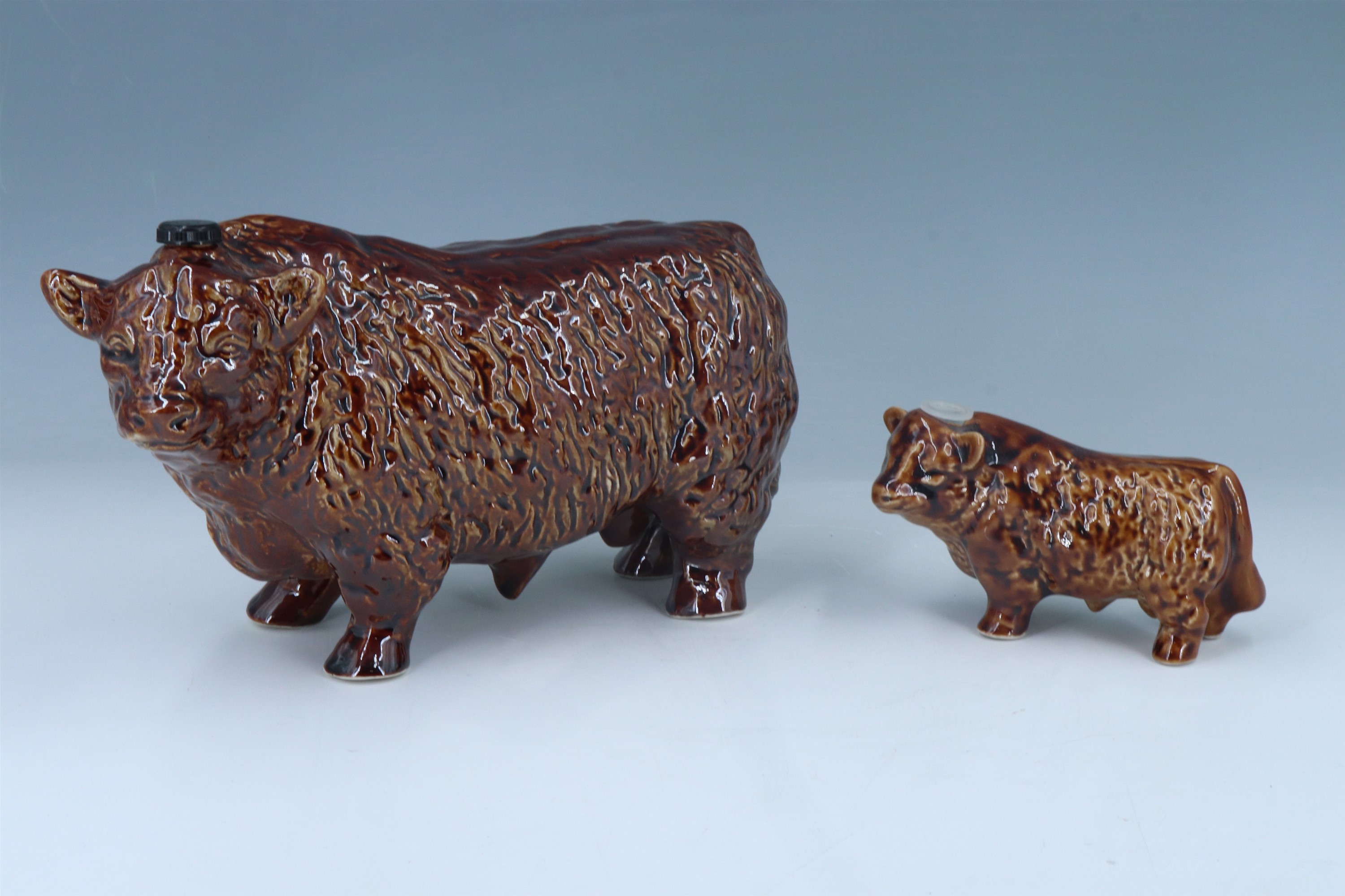 Two highland cow ceramic decanters, tallest 14 cm