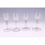 Four Georgian plain-stemmed wine glasses, two having an etched bowl and three having a folded