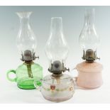 Three late 19th / early 20th Century glass finger lamps, comprising mottled pink, green, and painted