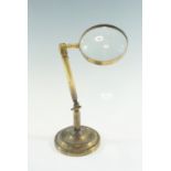 A late 19th / early 20th Century magnifying glass on adjustable brass stand, lens 4-inch, 27 cm to