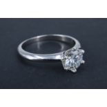 A modern Moissanite solitaire ring, having a one carat brilliant crown set between tapering