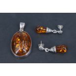 A late 20th Century Polish sun-spangled amber pendant, having an oval amber cabochon bezel set in