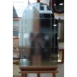 A 1950s frameless mirror of shouldered form and having an arched top, 92 x 56 cm