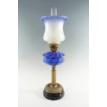 A Victorian columnar brass and blue glass oil lamp, having a two tone blue font, a duplex coronet