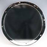 A 1950s circular frameless mirror decorated with an inscribed line and reverse polished buttons,