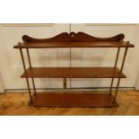 An early 20th Century mahogany and brass three tier wall bracket / shelves, the shaped crest rail