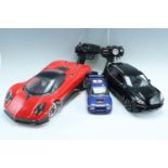 Three radio controlled cars, comprising a Porsche Cayenne Turbo, a Subaru and a red sports car,