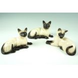 Three Royal Doulton / Beswick Siamese cat figurines, 11 cm tallest