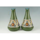 A pair of early 20th Century Secessionist ceramic vases, of elongated oviform, bases having