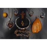 A large group of amber, white metal and other jewellery including an openwork bangle set with a