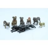 Five cold painted bronze figures of pug dogs, together with a cast brass example, and a pair of