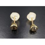 A pair of vintage diamond stud earrings, each having a 3.5 mm brilliant diamond bezel set in a