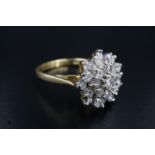 A late 20th Century cluster set diamond dress ring, comprising a 3 mm brilliant diamond above a