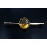 An early 20th citrine bar brooch, having a 13 x 12 mm citrine bezel set on a 9 ct yellow metal