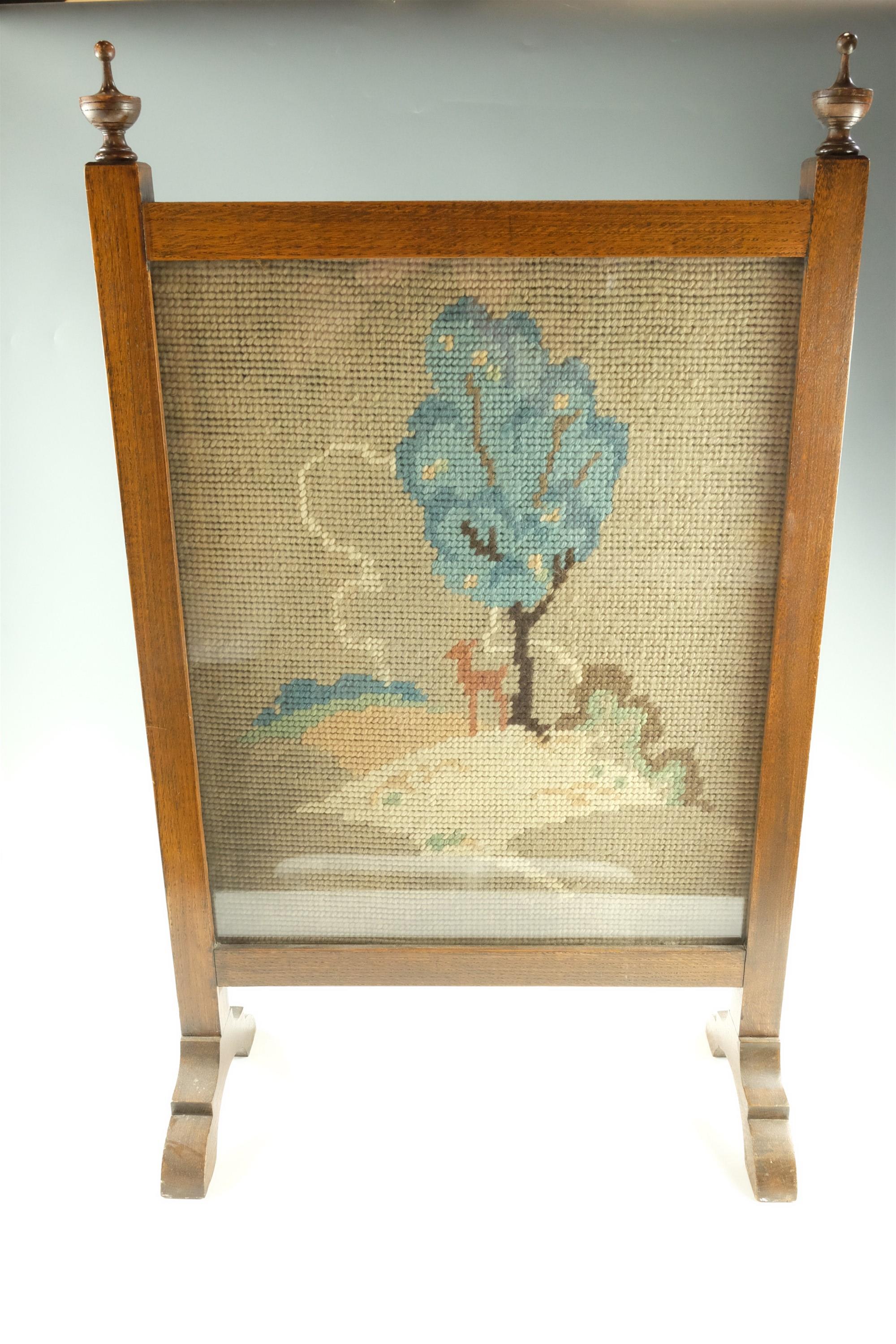 A George VI oak firescreen, having a gross-point tapestry landscape, 50.5 x 84 cm