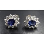 A pair of sapphire and diamond cluster earrings, each comprising an oval-cut sapphire of approx .6
