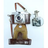 An Agfa Silette Pronto camera together with a desk-top adjustable magnifying glass