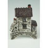 A porcelain model of Bridge House in Ambleside, the smallest house in Britain, bearing a gold anchor