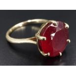 A modern 9 ct gold and ruby dress ring, having a 12 mm brilliant cut stone, basket-set between
