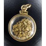 A late 20th Century locket containing gold nuggets, 3.59 g (of which nuggets 1.98 g), 18 mm diameter