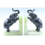 A pair of 1920s / 1930s patinated bronze and onyx 'rearing elephant' book ends, (a/f), each 11 x 5.5