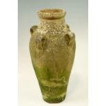 A late 20th Century terracotta amphora style vase, having four loop handles, 57.5 cm