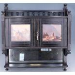 A Victorian Aesthetic parcel gilt ebony and mirror backed-wall hanging cabinet, its panelled doors