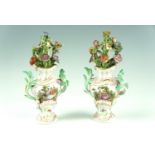 A pair of mid to late 20th Century German porcelain mantle ornaments, each modelled as an urn