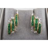 A pair of mid to late 20th Century emerald and diamond earrings, each comprising a central cuff of