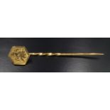 A mid 20th Century 9 ct yellow metal stick pin with engraved depiction of a bather, marked '9 ct',