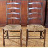 A pair of mid-to-late 20th Century oak ladder back rush-seat dining chairs, 104 cm high