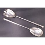 A pair of 1920s silver salad servers, having tapering rod form handles with canted terminals,
