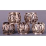 A set of five white metal Egyptian napkin rings, each of drum form comprising an open work