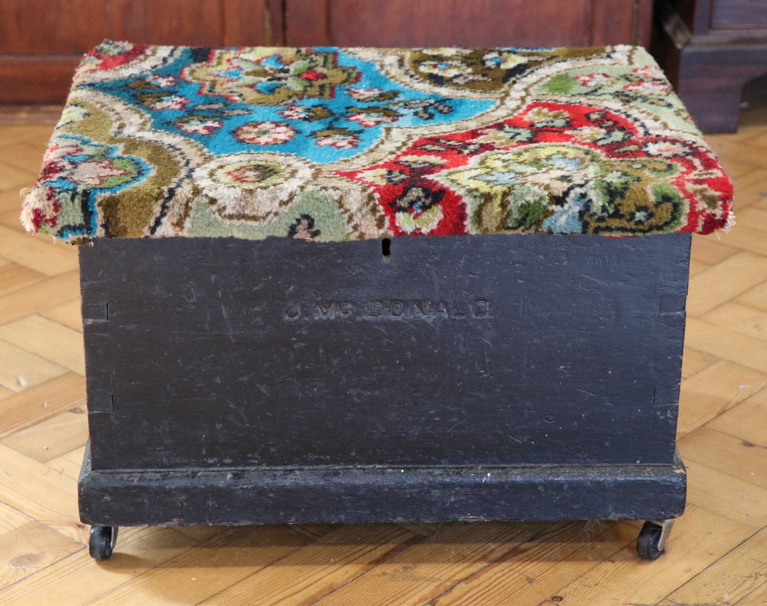 An early 20th Century painted pine tuck box, having an internal compartment and a carpet covered