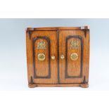 A Victorian novelty oak table cabinet in the form of a miniature safe, having a pair of doors with