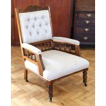 An Edwardian upholstered oak open arm elbow chair, having turned gallery back and sides, 97 cm high