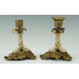A pair of late 19th Century cast brass and porcelain candlesticks, each having a finely worked