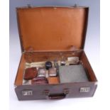 A vintage hide case containing a group of gentlemen's dressing accessories, including a razor,