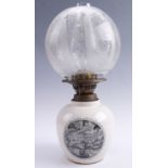 A transfer printed porcelain oil lamp having an etched glass globe, 40 cm