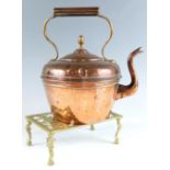 A late 19th / early 20th Century copper kettle together with a cast brass trivet decorated in