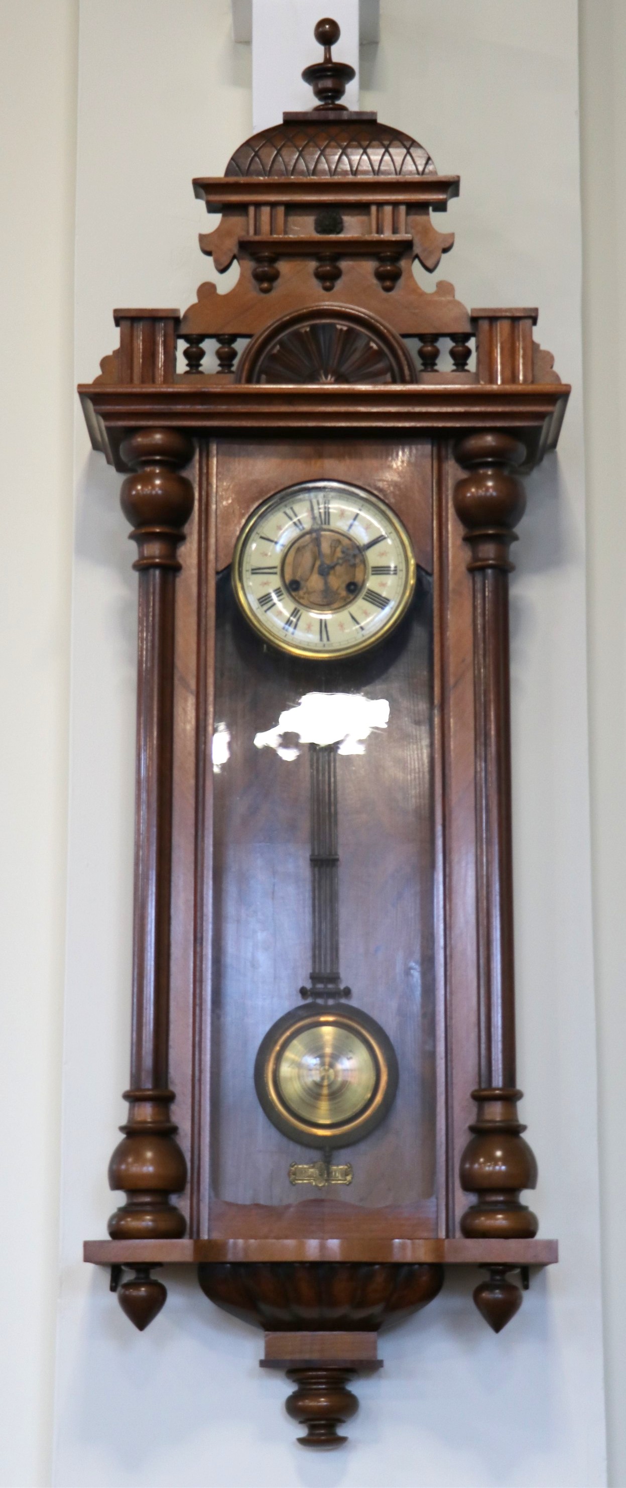 A 1920s walnut Vienna wall clock, having a two train spring movement striking on a gong, 48 x 18 x