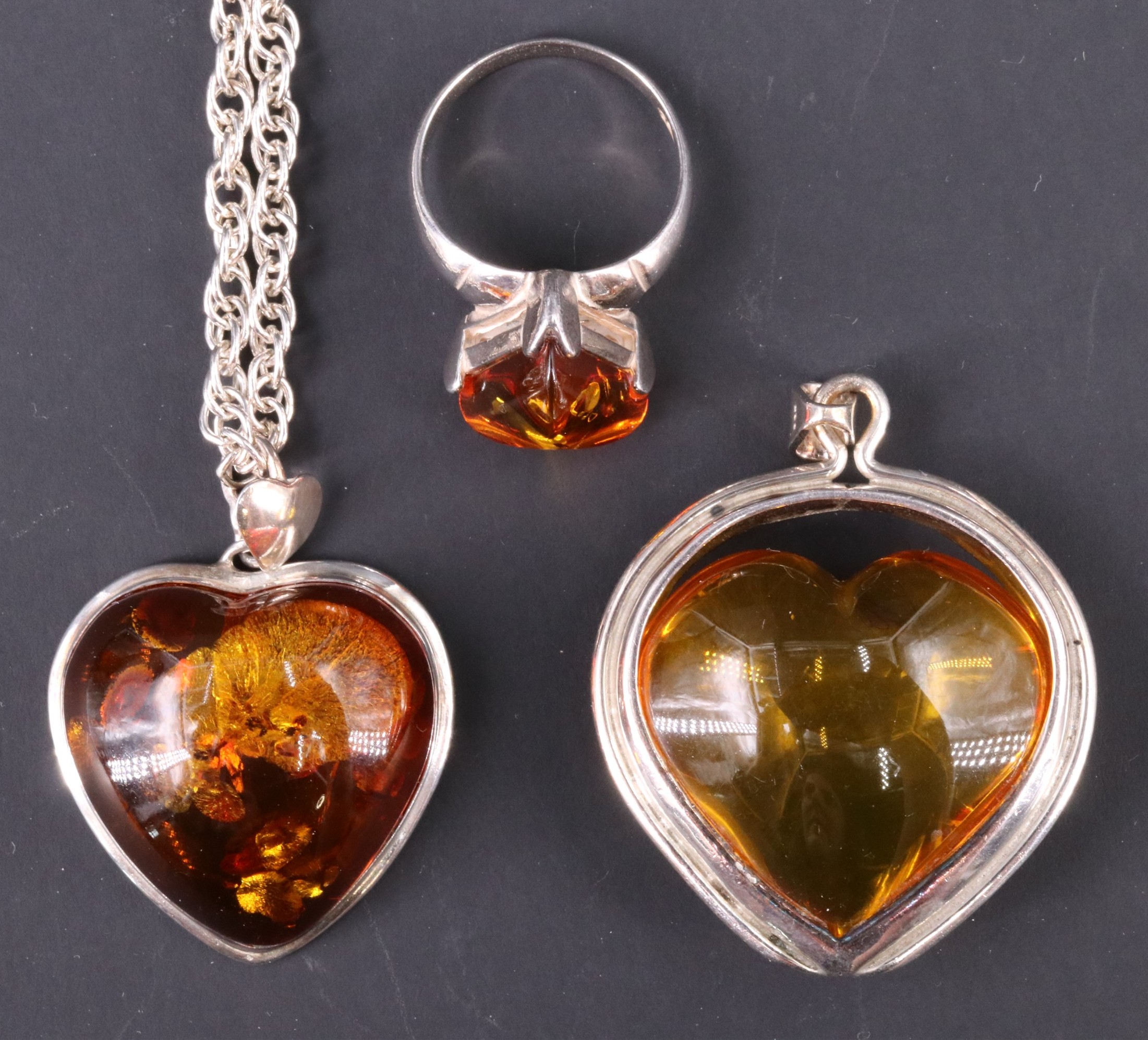 A contemporary sun spangled amber pendant necklace, being a 25 x 25 mm heart shaped amber cabochon